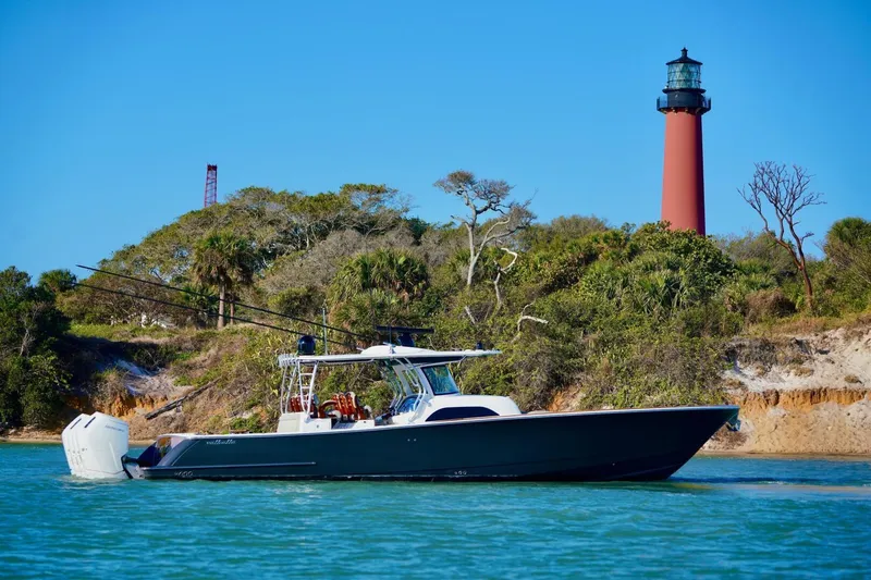 Slide: The Image of 2021 Valhalla Boatworks V46 cruising near a lighthouse with lush greenery. - 2