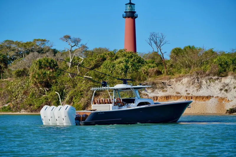 Slide: The Image of 2021 Valhalla Boatworks V46 cruising near a lighthouse with lush greenery in the background. - 4