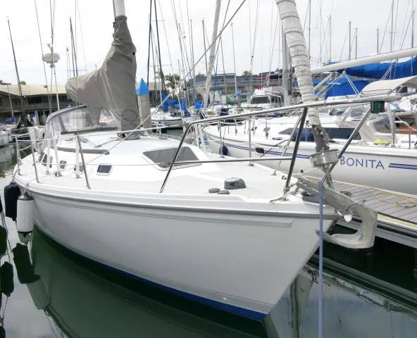 Slide: The Image of 1988 Catalina 34 sailboat docked in a marina, surrounded by other boats. - 1