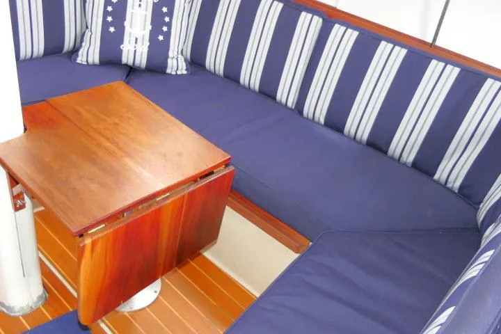Slide: The Image of Interior of 1988 Catalina 34 sailboat with blue striped seating and wooden table. - 10