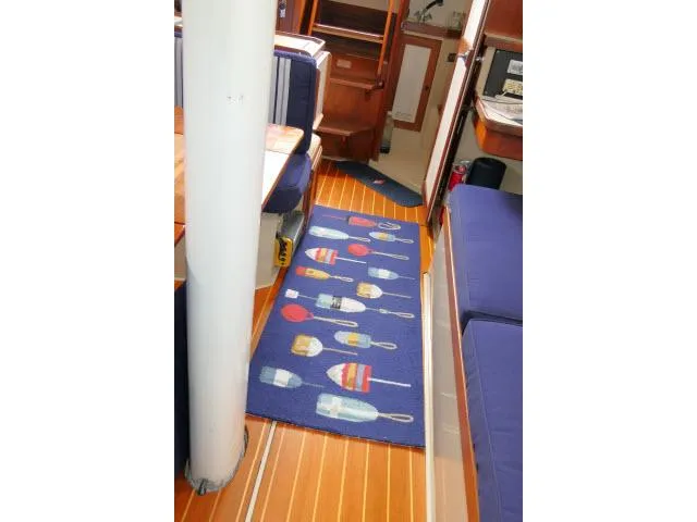 Slide: The Image of Interior of 1988 Catalina 34 sailboat with nautical-themed rug and wooden flooring. - 11