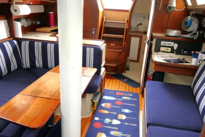 Slide: The Image of Interior of a 1988 Catalina 34 sailboat with striped seating and wooden accents. - 12