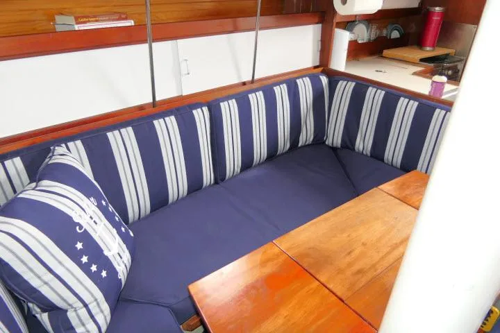 Slide: The Image of Interior of 1988 Catalina 34 sailboat with striped cushions and wooden table. - 14