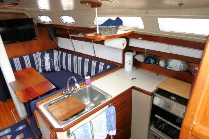 Slide: The Image of Interior of 1988 Catalina 34 sailboat with kitchen and seating area. - 15
