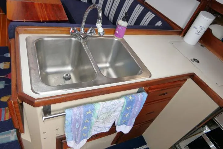 Slide: The Image of 1988 Catalina 34 yacht kitchen with double sink and wooden cabinetry. - 16
