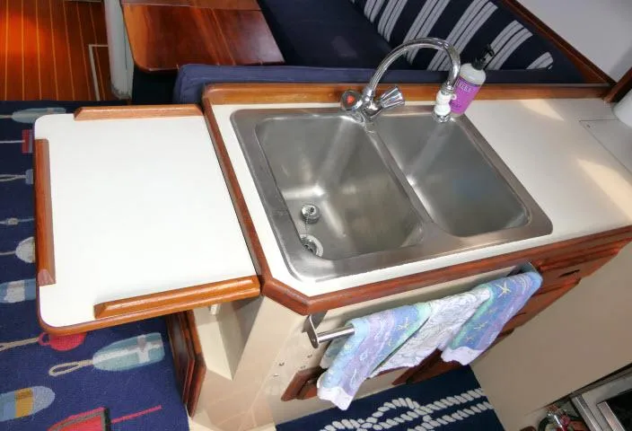 Slide: The Image of 1988 Catalina 34 yacht kitchen sink with dual basins and wooden accents. - 18