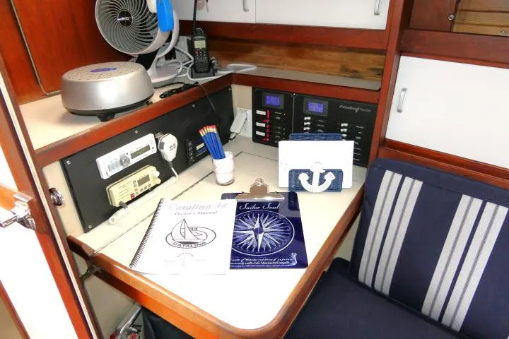 Slide: The Image of Navigation station in a 1988 Catalina 34 sailboat with manuals and nautical decor. - 22