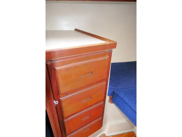 Slide: The Image of Interior of 1988 Catalina 34 sailboat with wooden drawers and blue cushioned seating. - 29