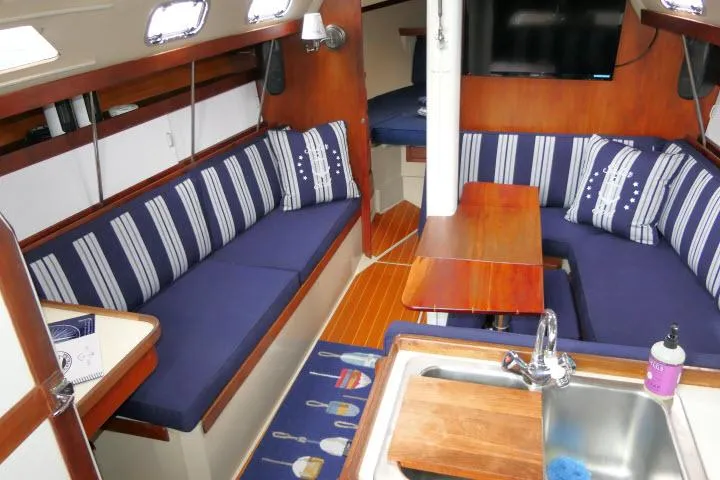Slide: The Image of Interior of a 1988 Catalina 34 sailboat with striped seating and wooden accents. - 3