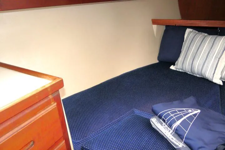 Slide: The Image of Cozy cabin interior of 1988 Catalina 34 sailboat with blue bedding and striped pillow. - 30