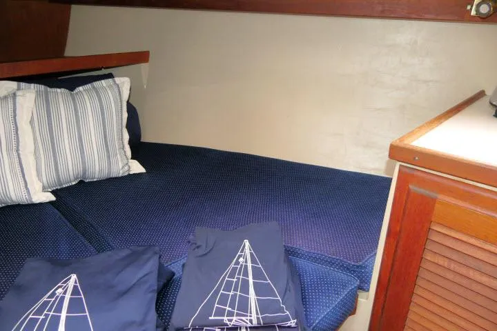 Slide: The Image of Cozy cabin interior of 1988 Catalina 34 sailboat with blue bedding and striped pillows. - 31