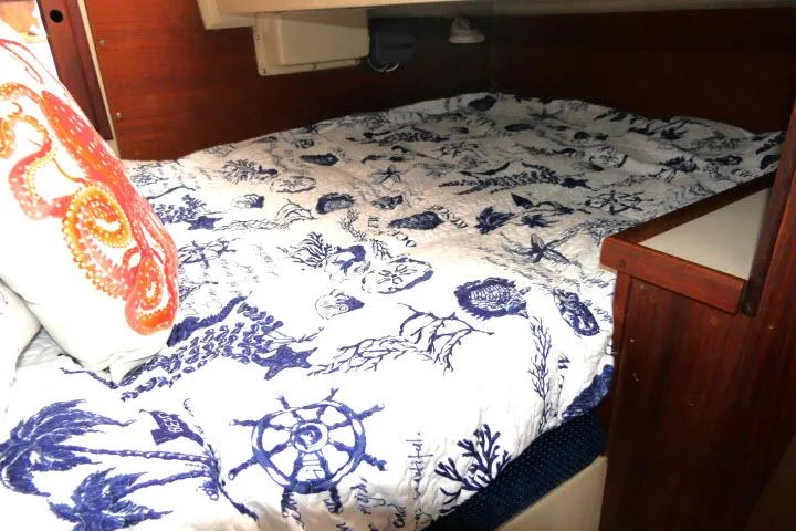 Slide: The Image of Cozy cabin bed in 1988 Catalina 34 sailboat with nautical-themed bedding and octopus pillow. - 35