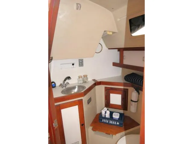 Slide: The Image of Interior of 1988 Catalina 34 sailboat, featuring compact sink and storage area. - 37