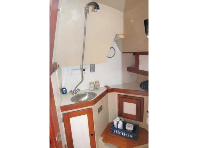 Slide: The Image of 1988 Catalina 34 yacht interior galley with sink, storage cabinets, and nautical decor. - 38