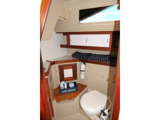 Slide: The Image of 1988 Catalina 34 yacht bathroom with wooden accents and compact design. - 39