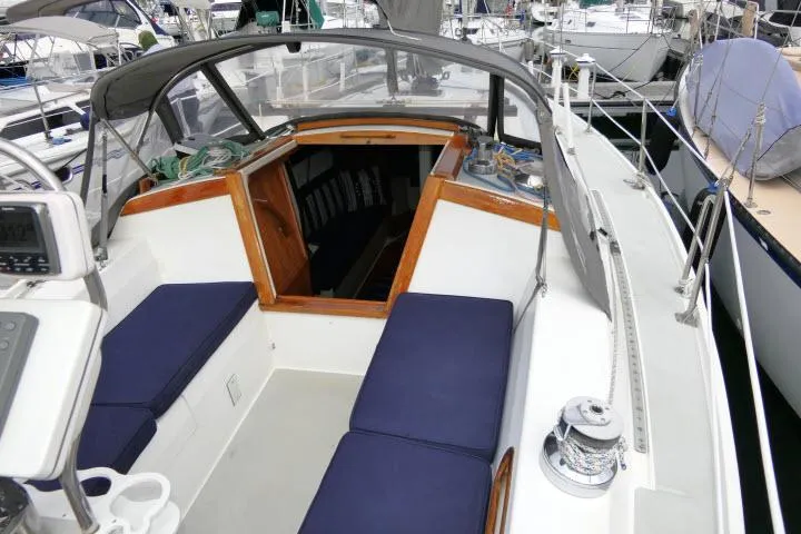 Slide: The Image of 1988 Catalina 34 sailboat cockpit with blue cushions, docked in a marina. - 46
