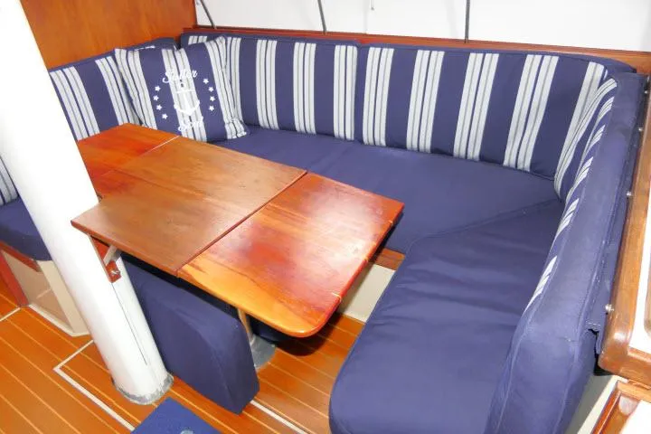 Slide: The Image of Interior of 1988 Catalina 34 sailboat with blue striped seating and wooden table. - 8
