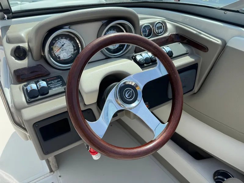 Slide: The Image of 2014 Crownline 235 SS boat dashboard with wood-accented steering wheel and gauges. - 10