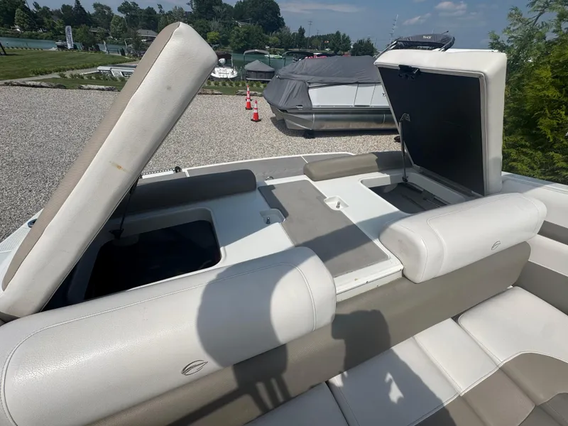 Slide: The Image of 2014 Crownline 235 SS boat interior with open storage compartments, beige and white seating. - 17