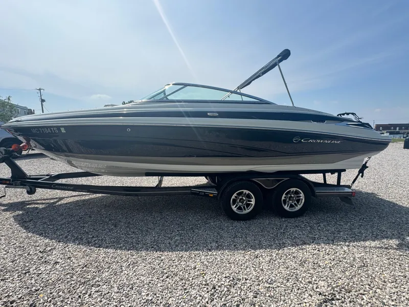 Slide: The Image of 2014 Crownline 235 SS boat on trailer, parked on gravel under clear sky. - 3
