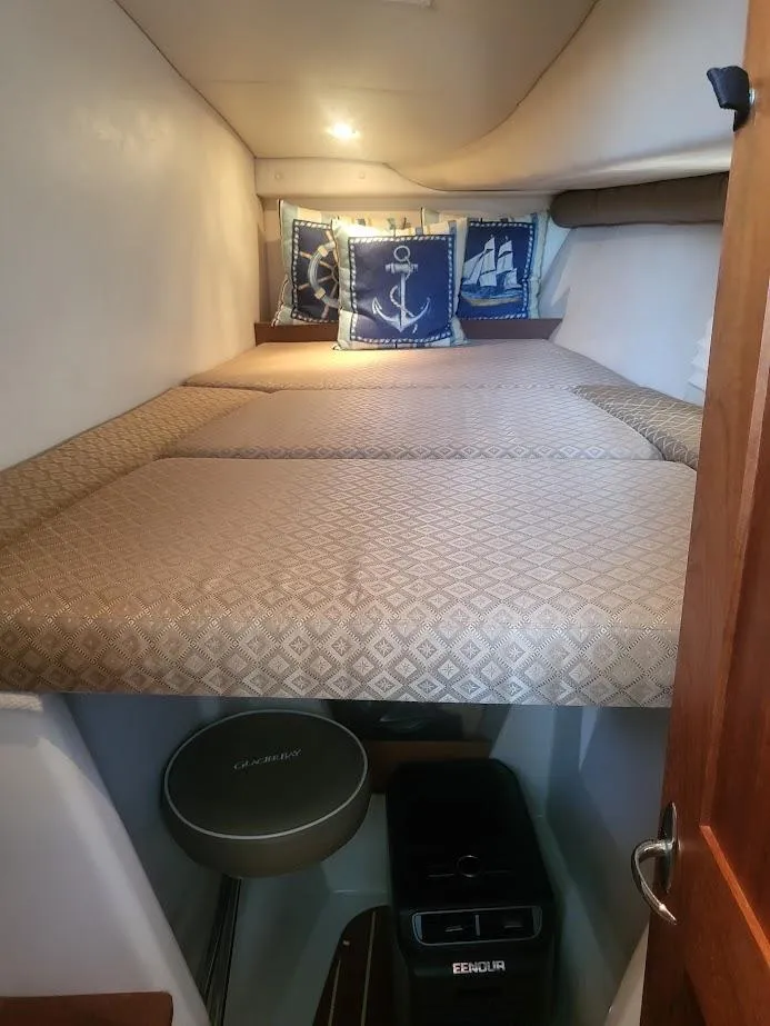 Slide: The Image of 2005 Glacier Bay 3480 Ocean Runner cabin with nautical-themed pillows and cozy bedding. - 12