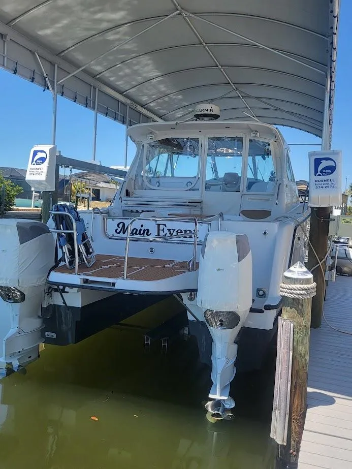 Slide: The Image of 2005 Glacier Bay 3480 Ocean Runner boat docked under canopy. - 3