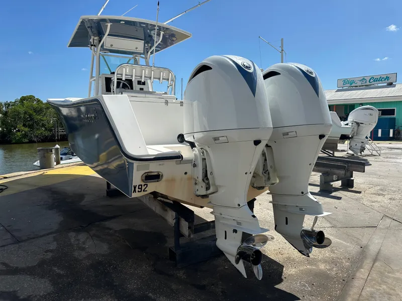 Slide: The Image of 2002 Regulator 32 Forward Seating boat with dual outboard engines at dockside. - 13
