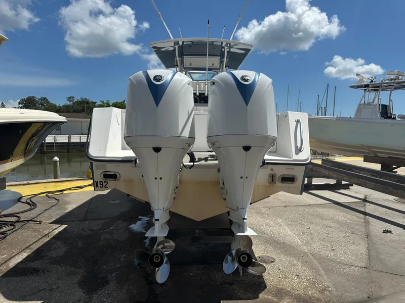 Slide: The Image of 2002 Regulator 32 Forward Seating boat with dual outboard engines on a sunny day. - 14