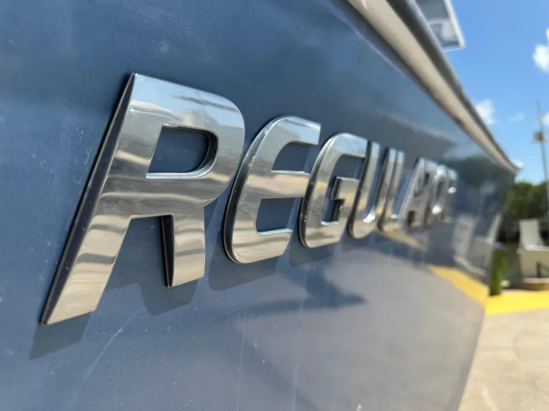 Slide: The Image of Chrome "Regulator" logo on a blue 2002 Regulator 32 Forward Seating boat. - 16