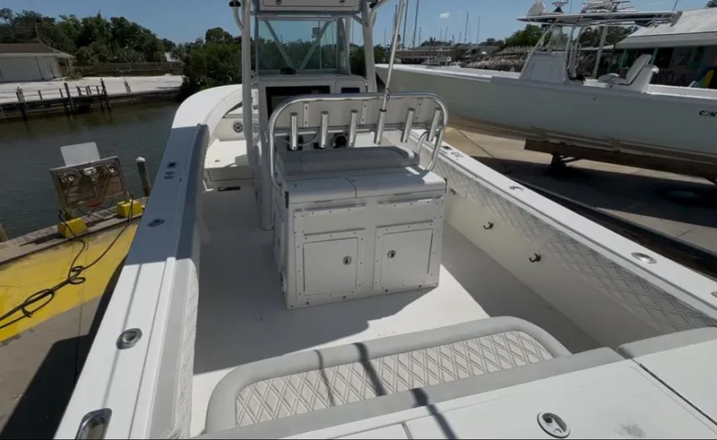 Slide: The Image of 2002 Regulator 32 Forward Seating boat docked, featuring spacious deck and seating area. - 17