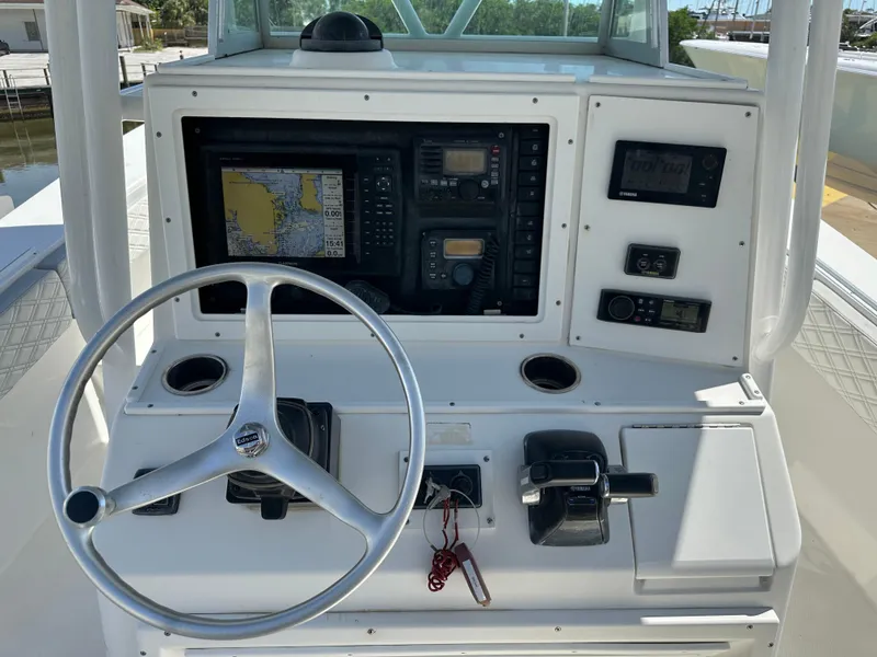 Slide: The Image of 2002 Regulator 32 Forward Seating boat dashboard with steering wheel and navigation controls. - 26