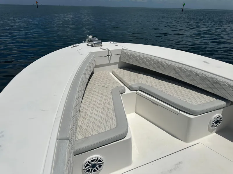 Slide: The Image of 2002 Regulator 32 Forward Seating boat with cushioned seats on calm water. - 36