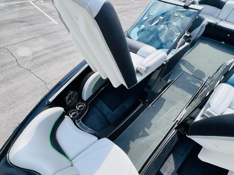 Slide: The Image of 2015 MasterCraft X25 boat interior with white seats, cup holders, and windshield. - 17
