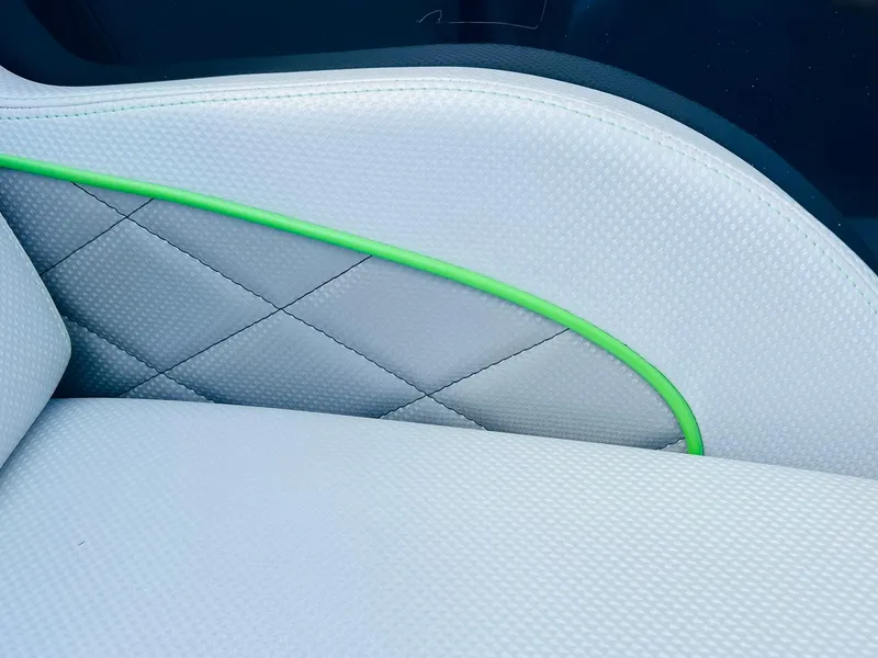 Slide: The Image of Close-up of 2015 MasterCraft X25 boat seat with green accent and diamond stitching. - 20