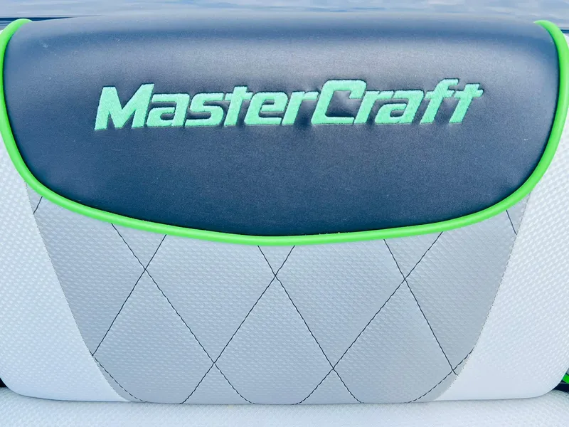 Slide: The Image of 2015 MasterCraft X25 boat seat with green trim and logo. - 21