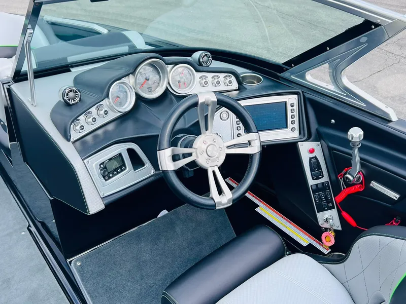 Slide: The Image of 2015 MasterCraft X25 boat dashboard with steering wheel, gauges, and control panel. - 31