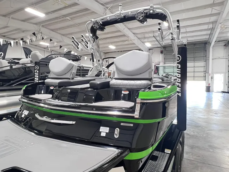 Slide: The Image of 2015 MasterCraft X25 boat with green accents in a showroom. - 39