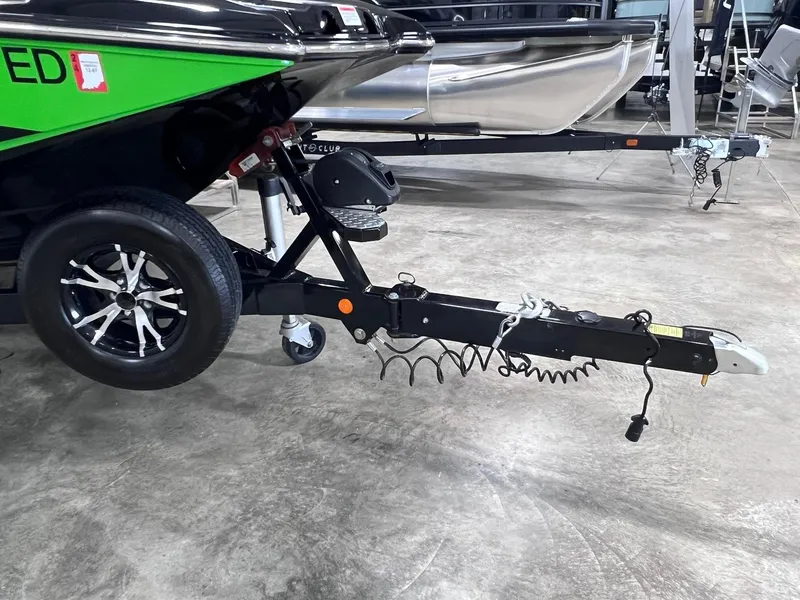 Slide: The Image of 2015 MasterCraft X25 boat trailer with black and green design in a showroom. - 40