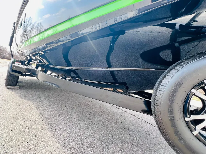 Slide: The Image of 2015 MasterCraft X25 boat on trailer, close-up view of hull and tire. - 48