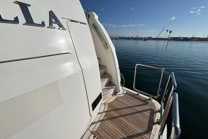 Slide: The Image of Stern view of 2010 Norseman 80 yacht with wooden deck and marina backdrop. - 120