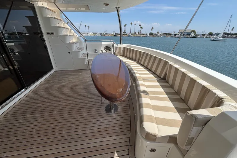 Slide: The Image of Luxury Norseman 80 yacht deck with striped seating, wooden table, and ocean view. - 134