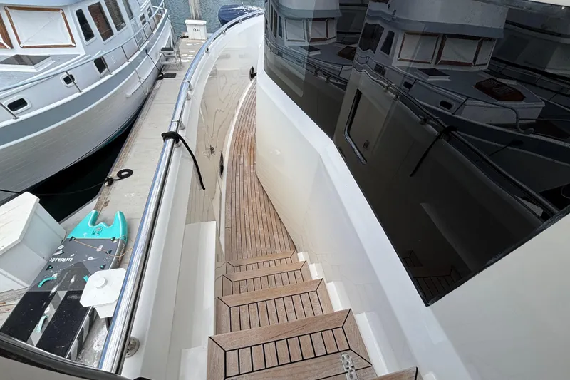Slide: The Image of Norseman 80 yacht deck with wooden steps, docked beside other boats, 2010 model. - 171