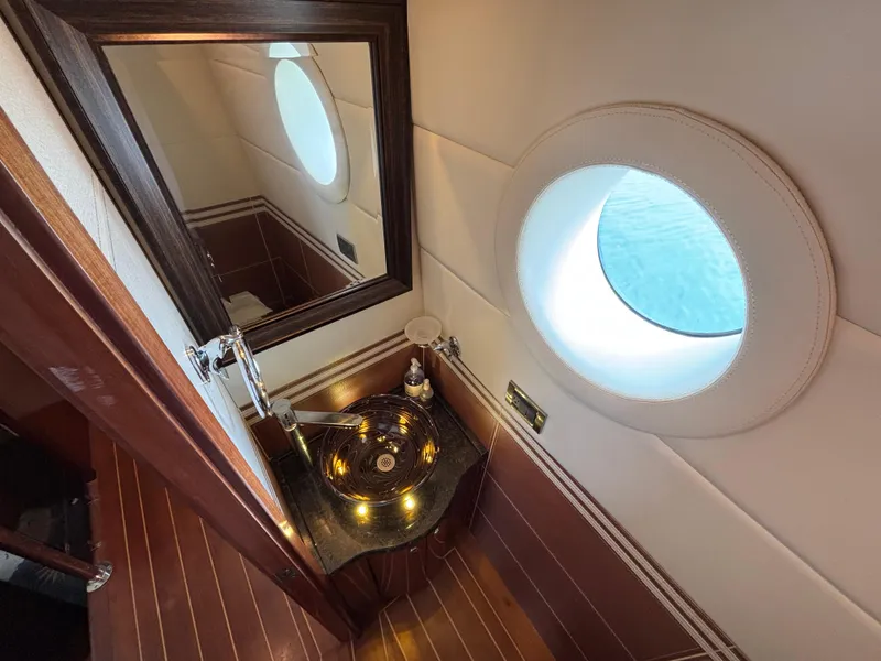 Slide: The Image of Luxurious Norseman 80 yacht bathroom with porthole, elegant sink, and wooden accents, 2010 model. - 21
