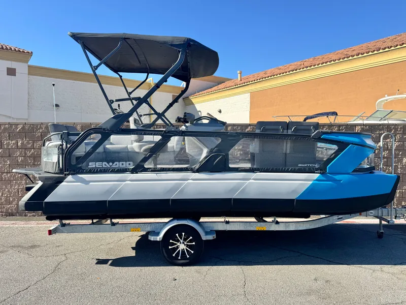 The Image of 2023 Sea-Doo Switch Cruise 21 pontoon boat on trailer, parked outdoors. - 0