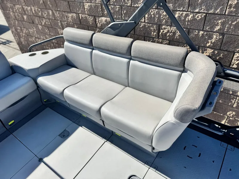 Slide: The Image of 2023 Sea-Doo Switch Cruise 21 interior seating with gray upholstery and cup holders. - 13