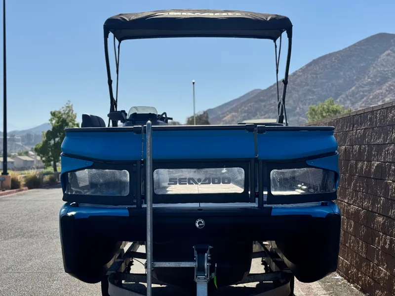 Slide: The Image of 2023 Sea-Doo Switch Cruise 21 pontoon boat with canopy, parked on a sunny day. - 2