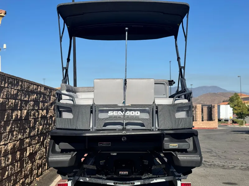 Slide: The Image of 2023 Sea-Doo Switch Cruise 21 pontoon boat, rear view, parked outdoors. - 5