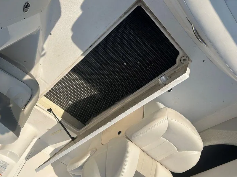 Slide: The Image of 2008 Chaparral 215 SSi boat interior with open storage compartment and white seating. - 23