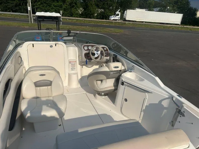 Slide: The Image of 2008 Chaparral 215 SSi boat interior with steering wheel and seating, parked outdoors. - 25