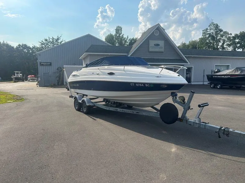Slide: The Image of 2008 Chaparral 215 SSi boat on trailer, parked outside dealership under a clear sky. - 4